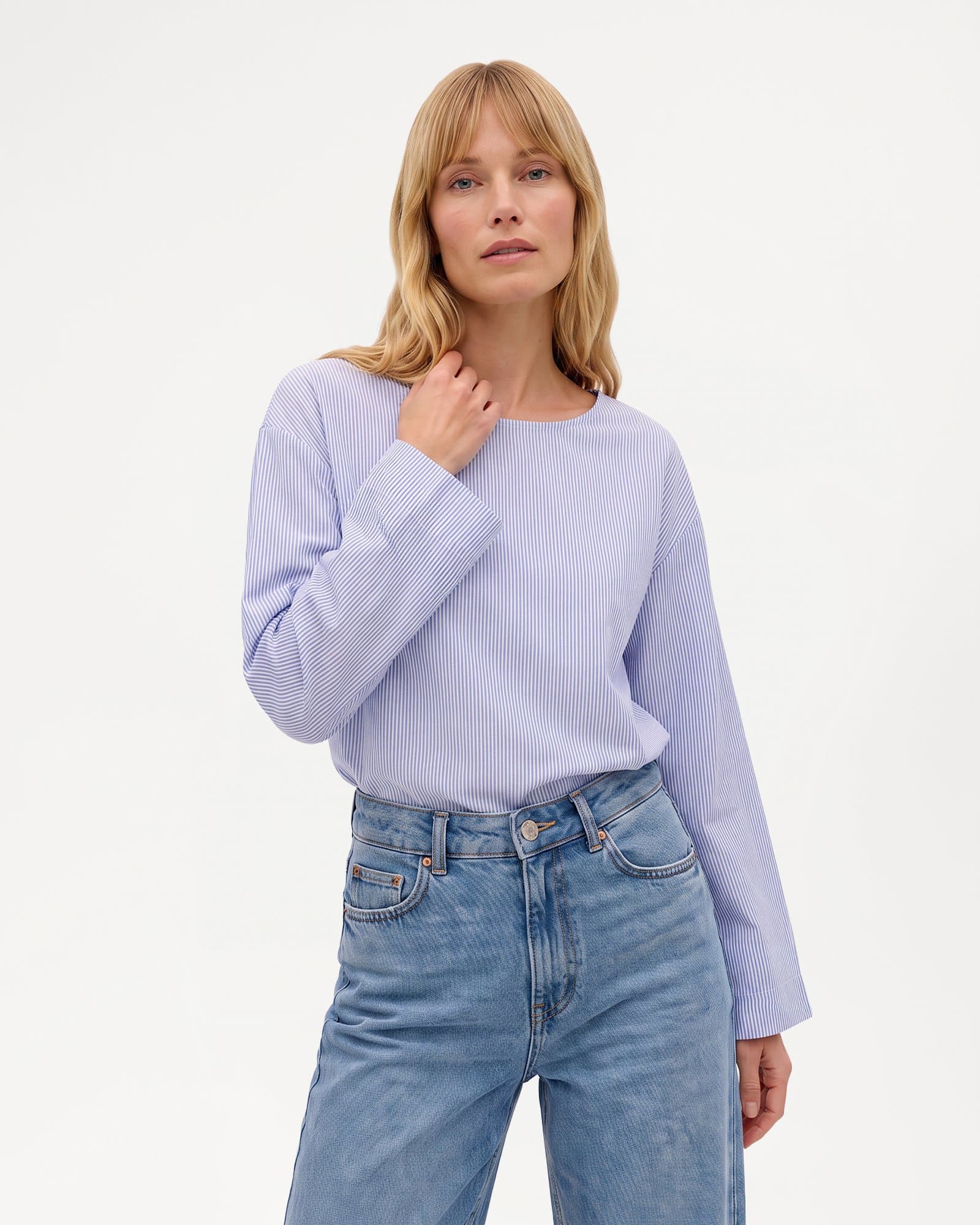 AI-generated image: blonde model in a lavender striped shirt and light blue jeans